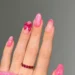 long oval nail with pink glitter design and 3d bow