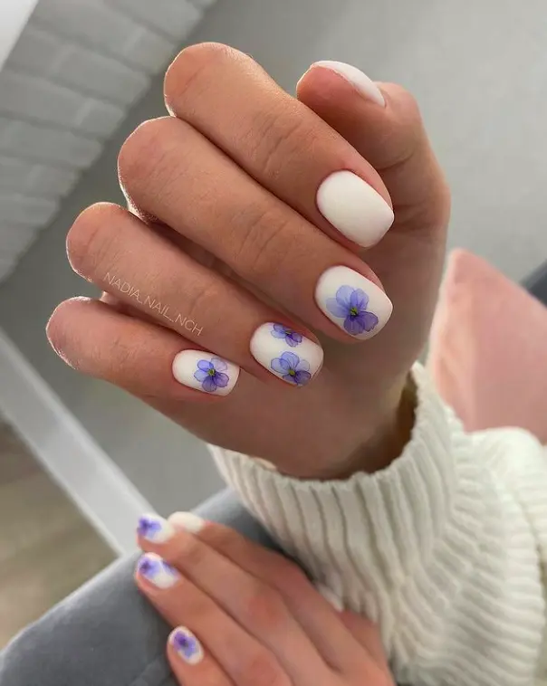 short square nails with purple flower art on white base